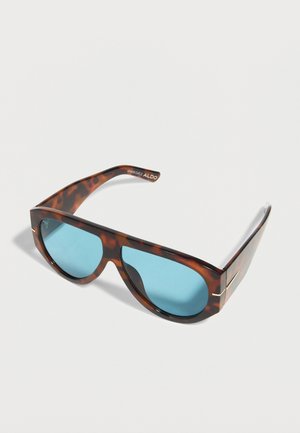 Sonnenbrille mit Schildpatt-Muster, blauen Gläsern und breitem Rahmen, mit dezentem goldfarbenem Akzent an den Bügeln und ALDO-Logo auf der Innenseite des Arms.