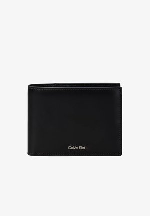 Cartera negra de cuero tipo bifold con bordes cosidos y pequeño logo plateado de Calvin Klein en el centro inferior frontal.