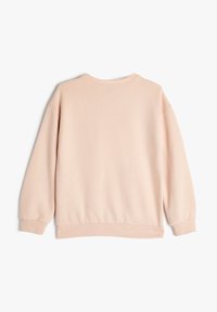 Sudadera rosa claro con cuello redondo, puños y dobladillo acanalados. Textura suave y corte relajado, con hombros caídos y diseño minimalista.