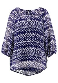 Lettet, gennemsigtig bluse med et marineblåt og hvidt zigzag-mønster. Den har en rund halsudskæring og elastiske, puffede ærmer.