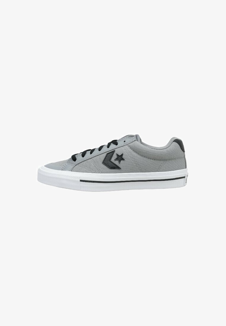 Baskets basses en toile grise avec lacets noirs, logo étoile noire sur le côté et semelle en caoutchouc blanche avec bande noire.