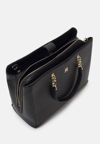 Sac à main en cuir noir avec anses en chaîne dorée, deux compartiments zippés et un petit logo métallique sur le devant.