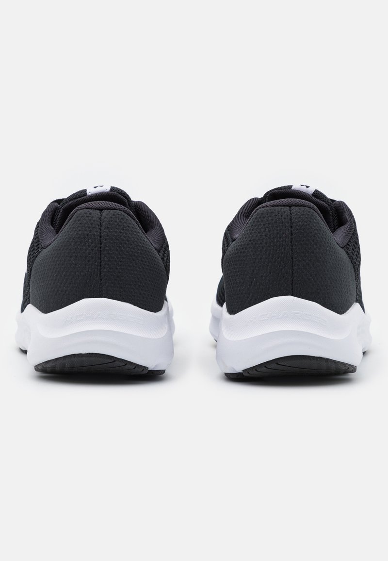 Zapatillas de malla negras con un diseño texturizado en la parte superior, suelas blancas y una marca sutil. Diseño de talón redondeado con un collar acolchado para mayor comodidad.