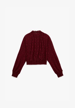 Burgunderfarbenes Spitzen-Crop-Top mit langen Ärmeln, hohem Kragen und gerafftem elastischen Saum. Das florale Muster verleiht Textur und Detail.