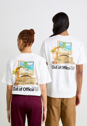 T-shirts blancs avec des graphismes au dos représentant un ordinateur vintage, une scène tropicale, et le texte "En vacances, absent du bureau depuis 95."
