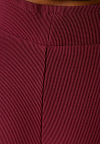 Bershka Tygbyxor - dark red