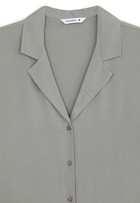 Camicia grigia chiaro con colletto classico, texture liscia e design semplice; presenta bottoni abbinati e nessun motivo aggiuntivo.