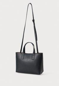 Must mustrehvide kott, millel on ülemised käepidemed ja reguleeritav õlarihm. Omab tekstuurset pind ja struktureeritud kuju.