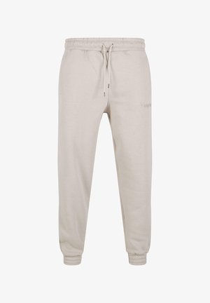Light beige sweatpants made of cotton blend, featuring an elastic waistband with drawstring, cuffed hems, and subtle logo detail.