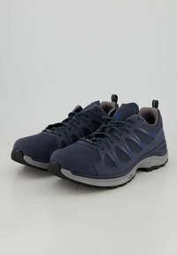 Scarpe da ginnastica di un blu scuro con dettagli grigi, in tessuto a rete, con suola ammortizzata e suola esterna in gomma testurizzata. Presentano lacci e un'etichetta per il trasporto.