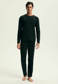 Czarny longsleeve i dopasowane spodnie wykonane z miękkiego materiału. Bluzka ma okrągły dekolt, a spodnie posiadają elastyczny pas i sznurek do regulacji.