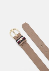 Cintura in pelle di un elegante marrone chiaro con una fibbia dorata. Presenta una banda decorativa nei colori blu navy, rosso e bianco con un accento logo. Superficie testurizzata.