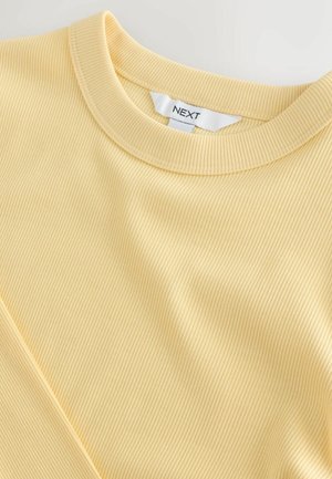 Gul ribbet bomulds T-shirt med rund hals og subtile lodrette striber, der fremhæver en glat tekstur og afslappet pasform.