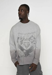 Grauer langärmliger Sweatshirt mit einem Grafiken-Design eines Adlers und zwei Bären, mit dem Text "Spirit of Multiply est. 2015". Weicher Stoff.