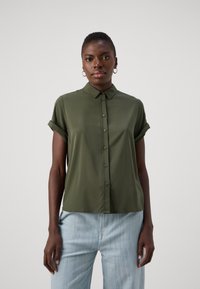 Kortermet olivengrønn skjorte med knapper foran og oppbrettede mansjetter; laget av et glatt stoff med rett passform. Uformell design.