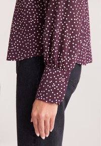 Bordeaux langemouwhemd met witte stippen; heeft gathered cuffs met knoopdetail; gladde stof, ontspannen pasvorm.