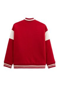 Sweat-shirt rouge avec des panneaux d'épaule blancs ; poignets et col côtelés de couleurs contrastées ; texture douce, coupe décontractée et sans graphiques visibles.