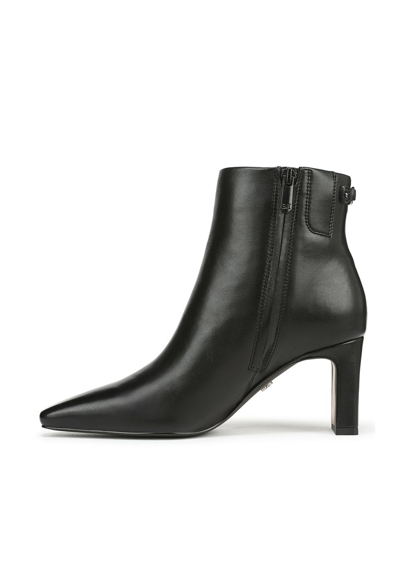 Bottes en cuir noir à la cheville avec un bout pointu, une fermeture éclair latérale et un design élégant. Le talon est de hauteur moyenne avec une finition brillante.