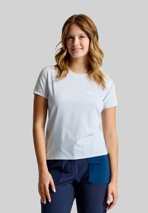 Lichtblauw T-shirt met korte mouwen, een ronde hals en een subtiel logo. De stof lijkt glad en lichtgewicht. Gecombineerd met marineblauwe broek met zakken van stof.
