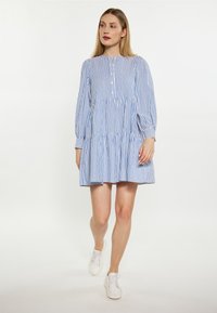 Abito a righe blu e bianche con maniche lunghe, design a strati, chiusura con bottoni al colletto e vestibilità comoda.