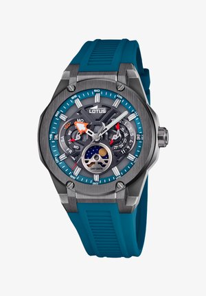 Męski zegarek z szarym stalowym kopertą, niebieskim gumowym paskiem, niebiesko-czarną tarczą, funkcją dnia i daty oraz świecącymi znacznikami godzin.