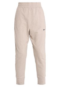 Pantalones jogger de color beige claro con una cintura elástica, tobillos ajustados y un pequeño logo negro en el muslo izquierdo. Material suave en mezcla de algodón.