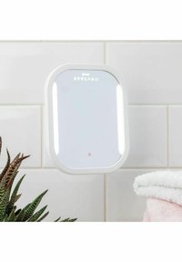 Väggmonterad spegel med vit ram, inbyggda LED-lampor, rektangulär form och STYLPRO-logotyp högst upp. Mjuk rosa handduk i närheten.