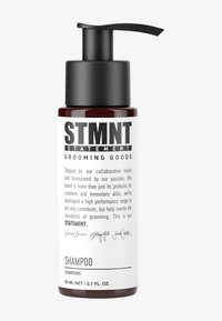 Bouteille de shampooing en verre brun avec une pompe noire, comportant un texte noir audacieux indiquant "STMNT GROOMING GOODS" ainsi que les détails du produit. Capacité de 80 ml.