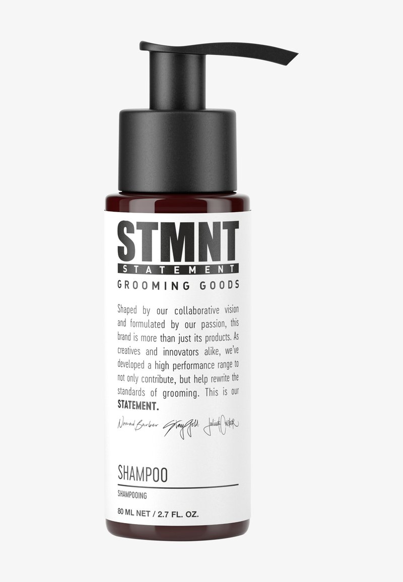 Brown glass shampoo bottle with a black pump, featuring bold black text stating "STMNT GROOMING GOODS" and product details. 80 ml capacity.