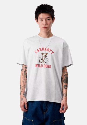 Maglietta in cotone grigia con una grafica di un cane giocoso e il testo "CARHARTT WILD DOGS" in rosso. Maniche corte, vestibilità rilassata e design con collo rotondo.