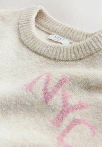 Cream sweater in soft wool blend, featuring ribbed neckline and light pink "NYC" lettering across the front. Textured surface detail present.