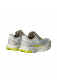 Grijze en witte sport schoenen met een bovenwerk van mesh, gele accenten en een dikke, gestructureerde zool. Bevat het logo van The North Face en VECTIV branding.