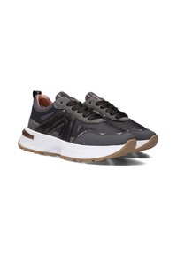 Sneakers in pelle nera con suola in gomma bianca e marrone. Le caratteristiche includono pannelli texture, lacci rotondi e una linguetta sul retro.