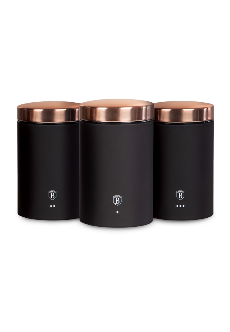 Tre contenitori cilindrici neri con coperchi di rame, disposti uno accanto all'altro, ognuno contrassegnato da un piccolo logo bianco e forme a diamante.