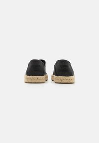 Espadrillas nere in tela con suola in juta naturale, caratterizzate da un profilo basso e design slip-on. La vista posteriore mostra un sottile dettaglio del marchio.