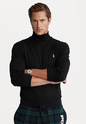 Zwarte coltrui met een aansluitend ontwerp, gecombineerd met groen en marineblauwe geruite joggingbroek. Bevat een gouden logo op de borst en een horloge om de pols.