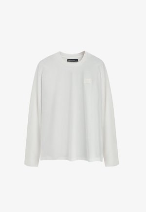 Camiseta blanca de manga larga hecha de algodón suave, con un escote redondo y un parche de logo cuadrado texturizado en el lado izquierdo del pecho.