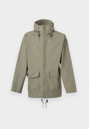 Világos olívazöld kapucnis dzseki elöl cipzárral, állítható húzózsinórokkal a kapucnin és az alján, valamint két patentos fedelű zsebbel.