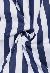 Katoenen stof met gedurfde marineblauwe en witte strepen, met een gladde textuur en een lichte glans, weergegeven in een gedraaid arrangement.