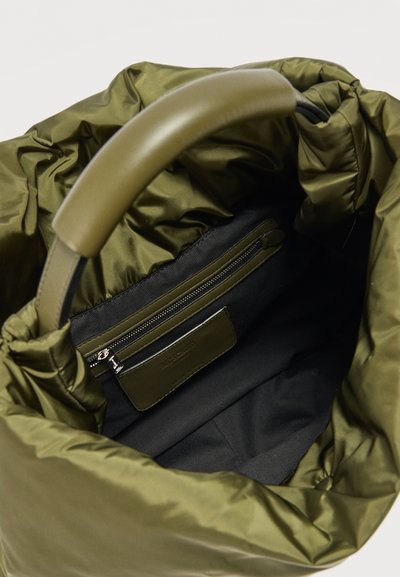 Τσάντα τύπου puffer σε ελιά πράσινο με μαξιλαρωμένη λαβή, μαύρη εσωτερική επένδυση και εσωτερική τσέπη με φερμουάρ και ετικέτα μάρκας.