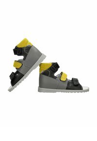 Scarpe alte grigie e nere con dettagli gialli, dotate di tre cinturini in Velcro regolabili e suola in gomma texture.