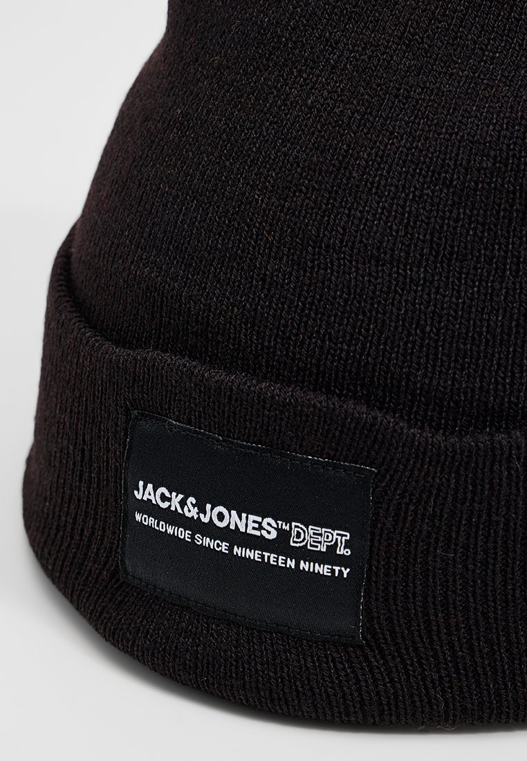 Zwarte gebreide beanie met een ribbelstructuur, voorzien van een gestikt label met de tekst "JACK & JONES DEPT." in witte letters op een zwarte achtergrond.