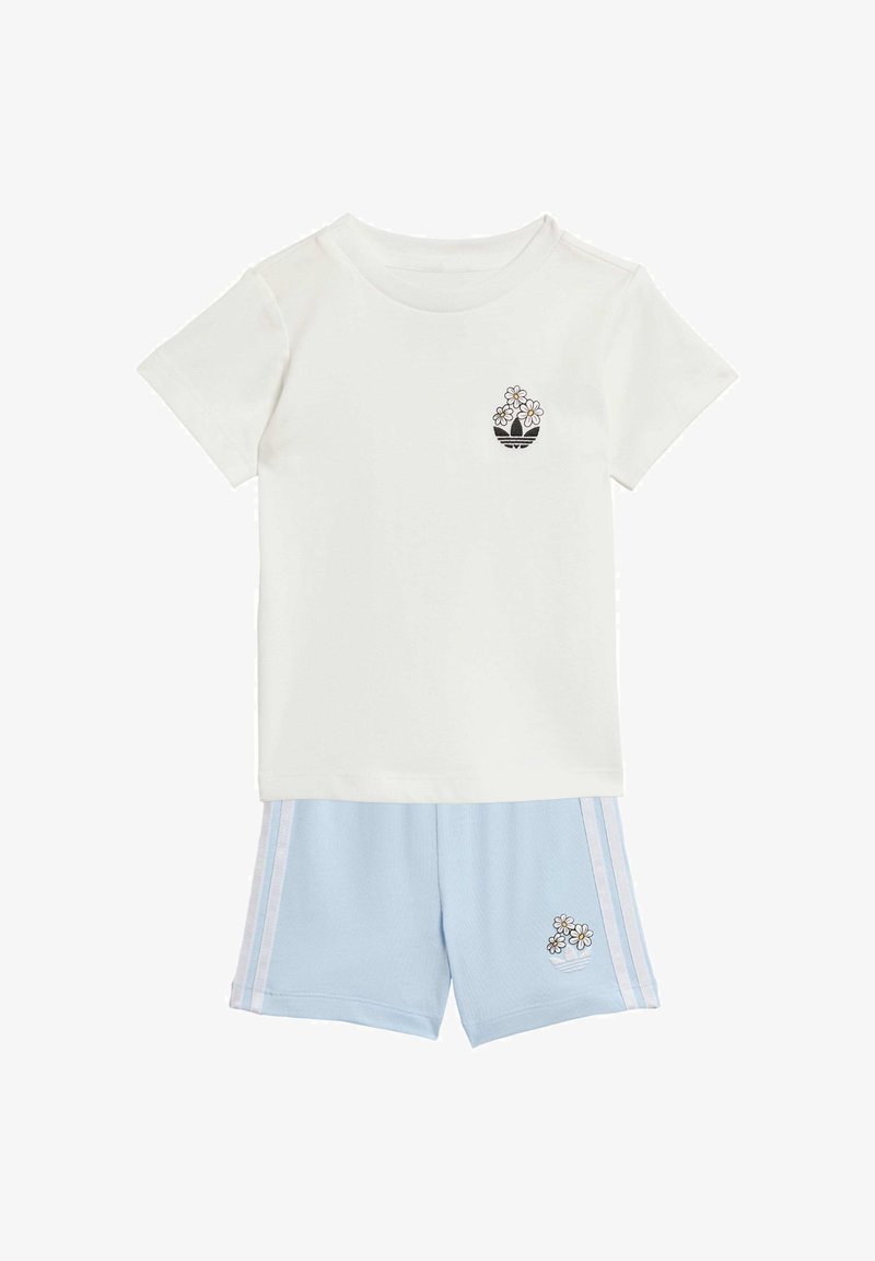 Ensemble t-shirt blanc à manches courtes et short bleu clair, tous deux avec de petits motifs floraux brodés en noir et blanc, short avec des bandes blanches sur les côtés.