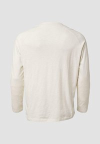 Koszula z długim rękawem w jasnobeżowym kolorze, wykonana z miękkiego materiału, z okrągłym dekoltem i rękawami raglanowymi, z gładkim, nieozdobionym tyłem.