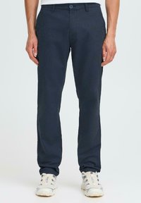 Pantalons marine en tissu léger, dotés d'une fermeture à bouton et de poches avant. Design à jambe droite avec une texture lisse.
