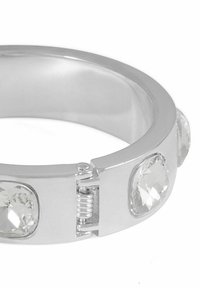 Silverfärgad metallarmband med tre ovala klara kristaller. Har en gångjärnslåsning och en slät, polerad yta.