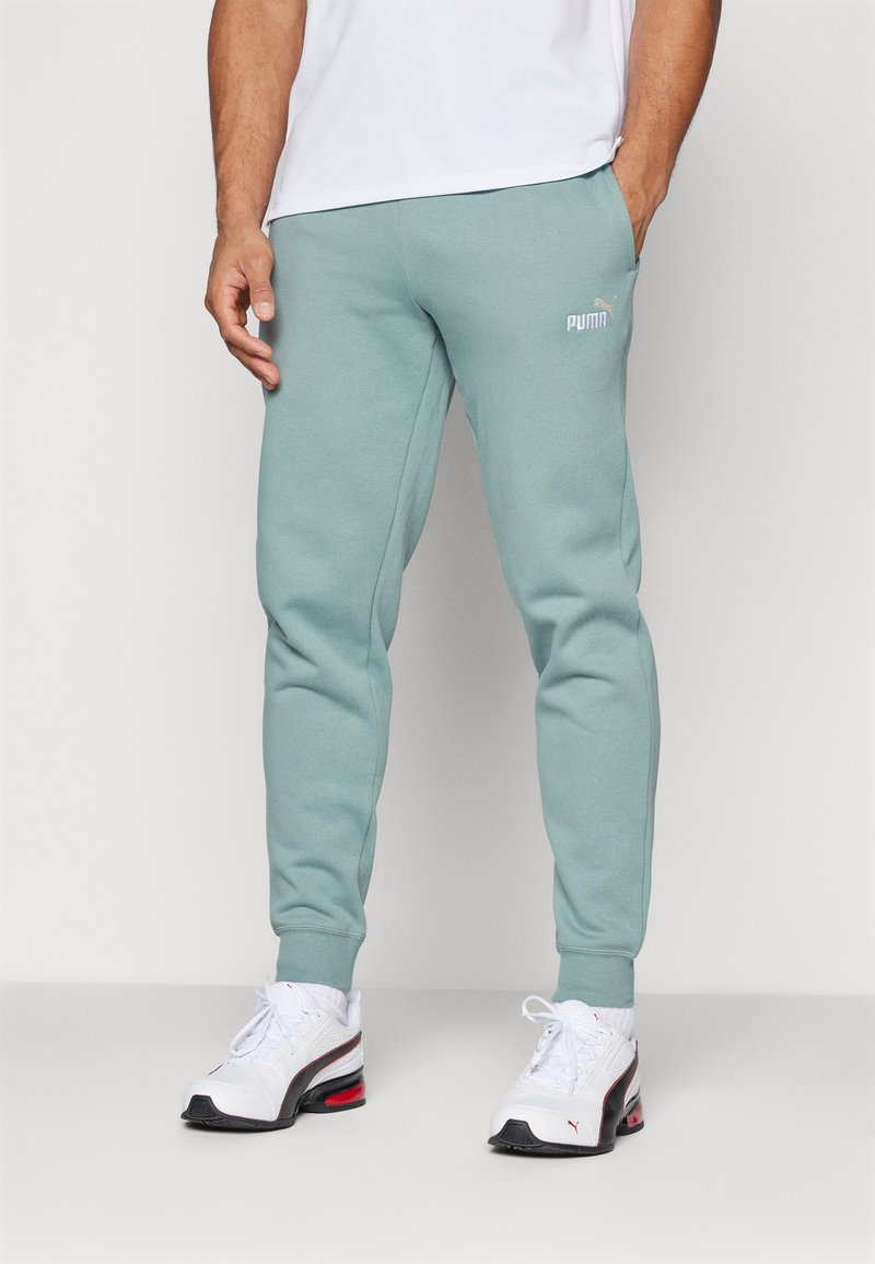 Šviesiai mėlynos jogger tipo kelnės su elastiniais sutraukėjais, šoninėmis kišenėmis ir mažuoju baltu "PUMA" logotipu šlaunies srityje. Pagamintos iš minkštos, kvėpuojančios medžiagos.