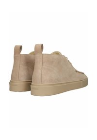 Sneakers alte in suede beige con lacci tonali, punta rotonda e suola in gomma testurizzata. Presentano un pull tab sul tallone per una facile calzata.