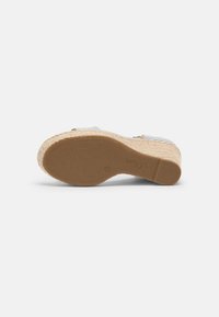 Sandale espadrille compensée avec semelle en caoutchouc texturée, talon plateforme recouvert de jute et empeigne en tissu rayé visible sur les bords.