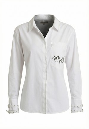 Camicia bianca a maniche lunghe con bottoni, colletto, taschino frontale con la scritta "Tokyo Rockin" e dettagli con borchie sulle maniche.